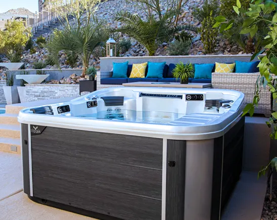 Modern hot tub spa with jets on luxury patio surrounded by blue cushioned seating