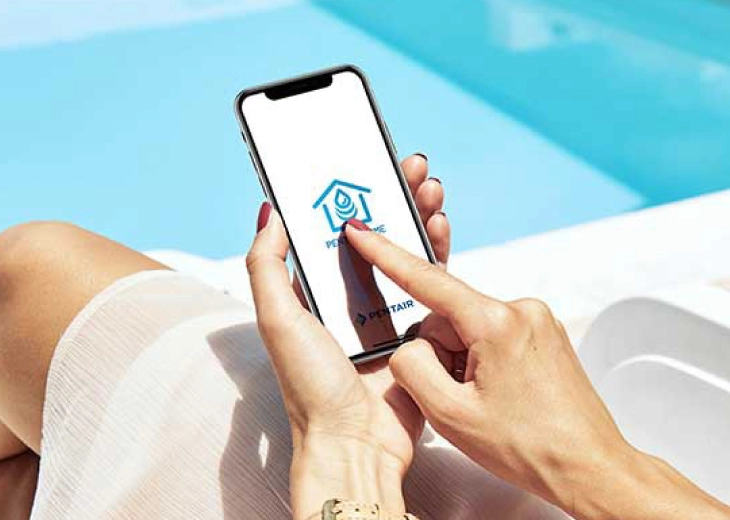 Person using pool maintenance app on smartphone by swimming pool