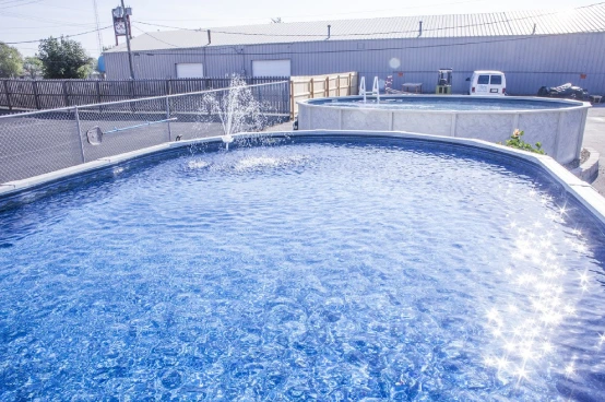 Large above-ground pool with crystal blue water and fountain feature at family pool facility