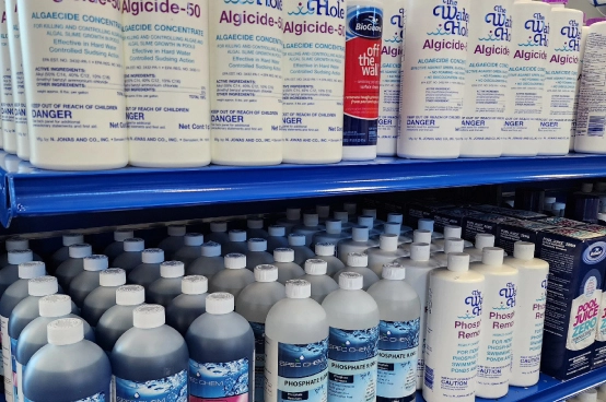 Pool maintenance products and algicide supplies displayed on retail shelves at The Water Hole